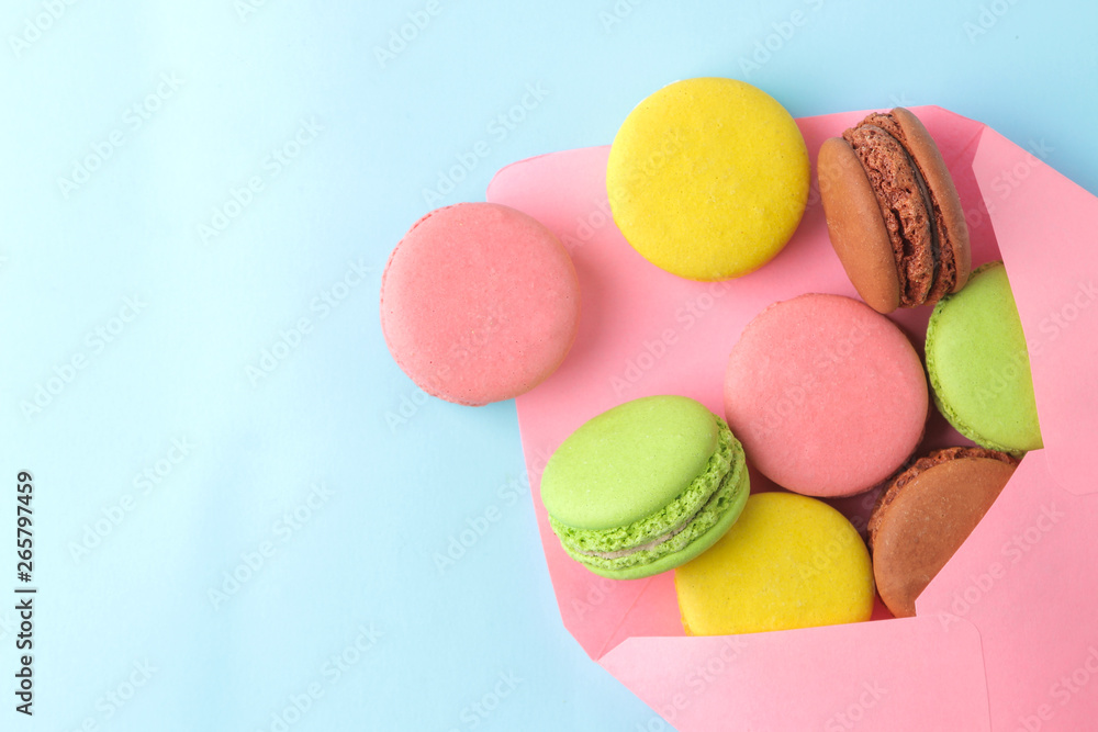 Macarons. french multicolored macaroons cakes in envelope. small french sweet cake on bright blue background. Dessert. Sweets. top view.