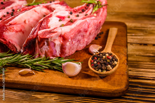 Raw pork ribs with spices, garlic and rosemary on a cutting board