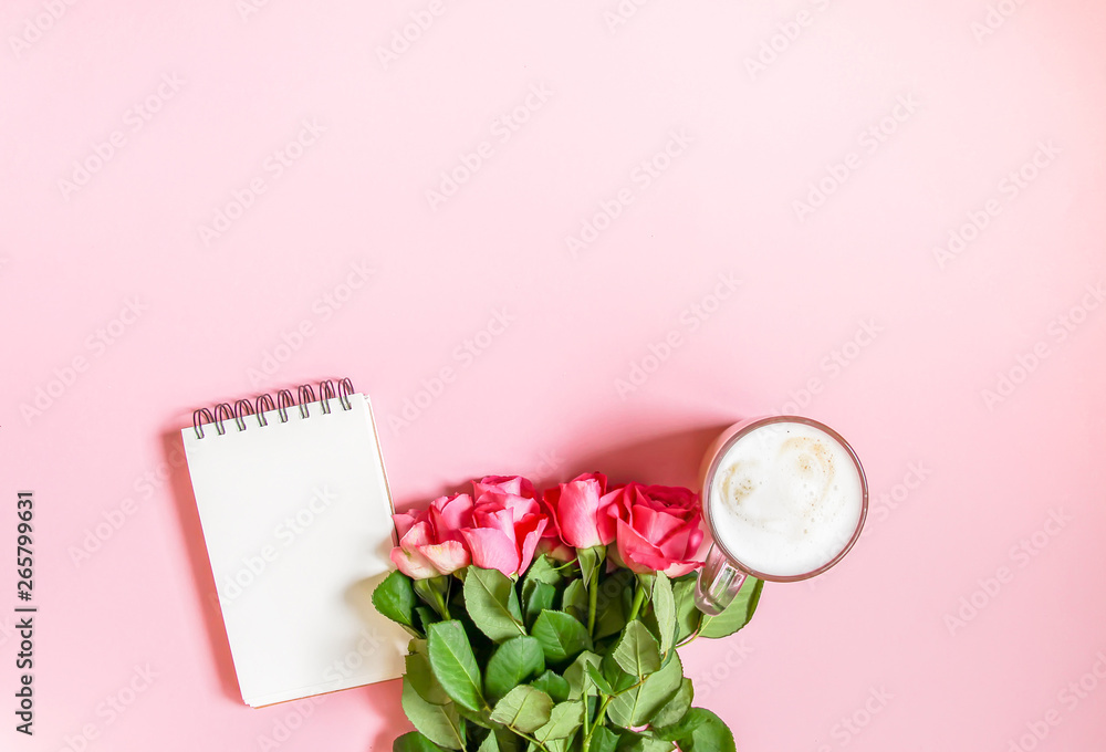 The cup of hot coffee, empty notepad with funny pen and bouquet of fresh roses on soft pink background. The cup of hot coffee, empty notepad with funny pen and bouquet of fresh roses on soft pink background.
