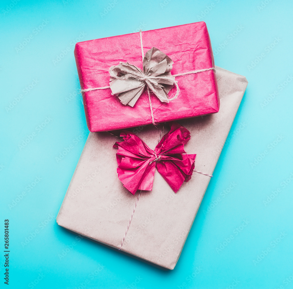 Greeting present boxes in wrapping paper with bow on blue background, top view. Flat lay. Congratulations, holiday,birthday concept