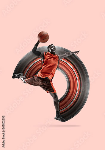 Full length portrait of a basketball player with a ball isolated on coral studio background. Fit african american athlete. Motion, activity, movement, advertising concept. Abstract design.