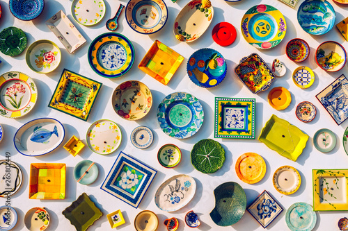 Collection of colorful Portuguese ceramic pottery, local craft products from Portugal. Ceramic plates display in Portugal. Colorful of vintage ceramic plates in Sagres, Portugal.