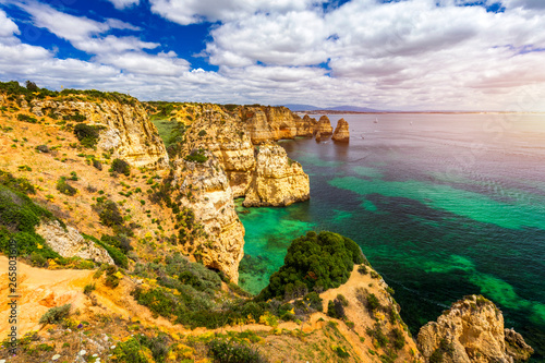 Panoramic view, Ponta da Piedade near Lagos in Algarve, Portugal. Cliff rocks and tourist boat on sea at Ponta da Piedade, Algarve region, Portugal. Ponta da Piedade, Algarve region, Portugal.