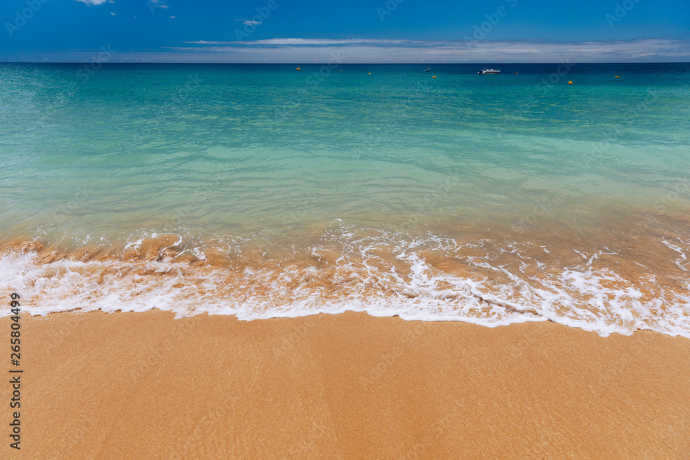 Blue ocean wave on sandy beach. Soft wave of blue ocean on sandy beach. Background. Top view of Beautiful beach with tranquil wave, sea and ocean background, summer vacation concept.