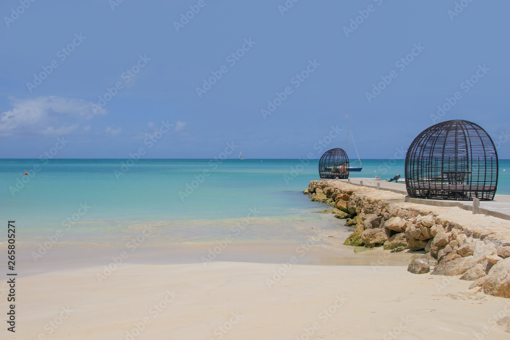 Fototapeta premium Sand Beach of Antigua, dream beach with a little sailboat on the horizon, Caribbean Sea