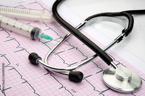 stethoscope on cardiogram with syringe