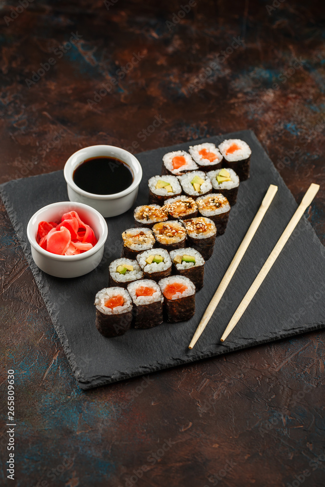 Japanese sushi on a rustic dark background. Japanese sushi on a rustic dark background.