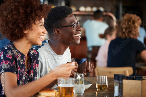 Couple On Date Meeting For Drinks And Food In Restaurant