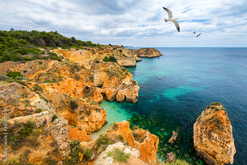 View of stunning beach with golden color rocks in Alvor town , Algarve, Portugal. View of cliff rocks on Alvor beach, Algarve region, Portugal. View of stunning beach with golden color rocks in Alvor town , Algarve, Portugal. View of cliff rocks on Alvor beach, Algarve region, Portugal.