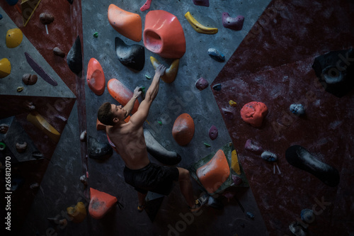 Athletic man practicing in a bouldering gym