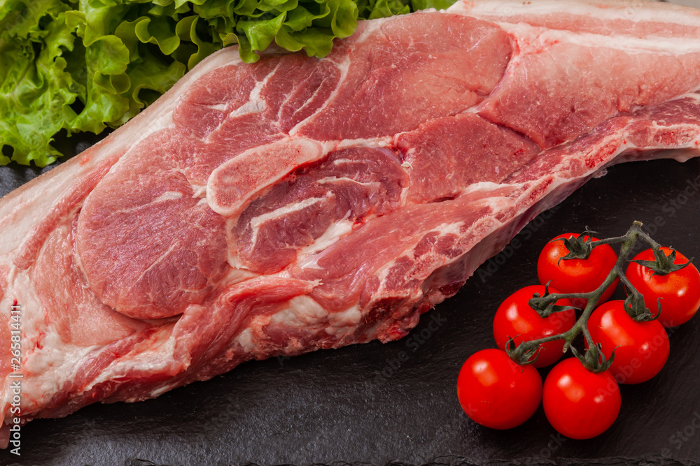 a piece of pork meat on the black plate a piece of pork meat on the black plate