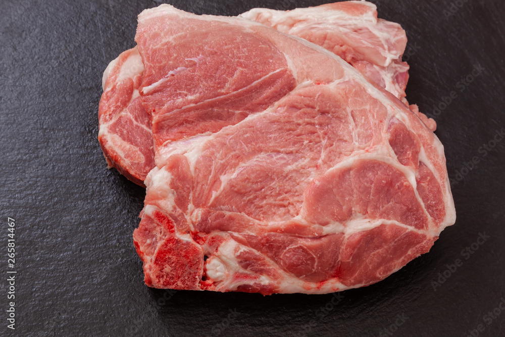 a piece of pork meat on the black plate a piece of pork meat on the black plate