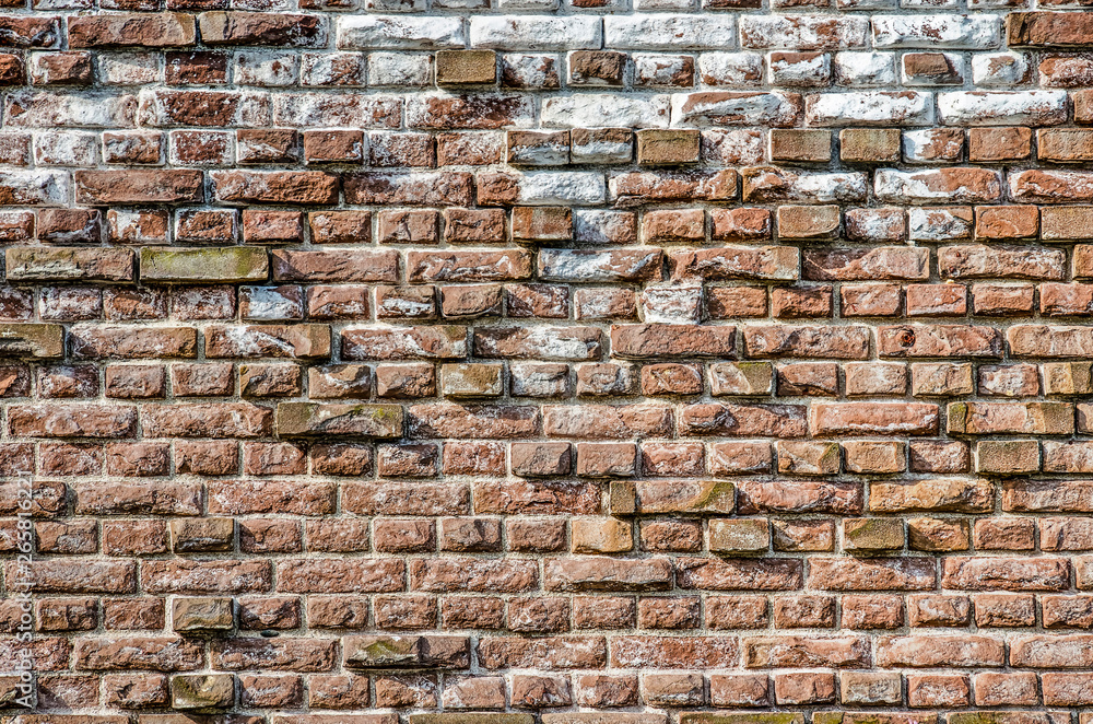 Old masonry wall with chalk and other impurities and with protruding bricks forming an irregular relief pattern Old masonry wall with chalk and other impurities and with protruding bricks forming an irregular relief pattern