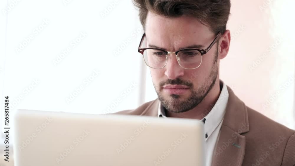 Handsome young business man working with laptop in the office. Handsome young business man working with laptop in the office.