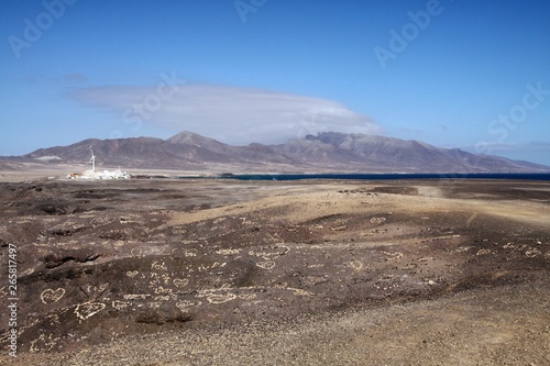 View on small white village, mountain range and spot of blue ocean over endless barren land, Fuerteventura, Canary Islands