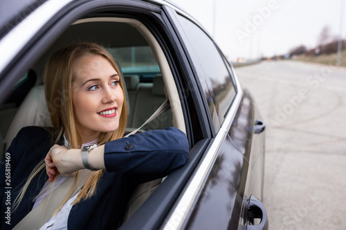 Beautiful young business woman is driving her car to work