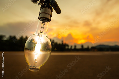 Light bulb on the beach and mountain background,lamp light with sunset,energy conceptLight bulb on the beach and mountain background,lamp light with sunset,energy concept photo