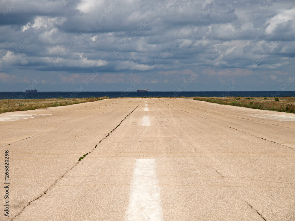 Sevastopol, Crimea - July 17, 2008: The peninsula of Crimea. Military airdrome on the Chersonesos cape. Empty runway strip. Crimean coast of Black sea. The highway to the sea
