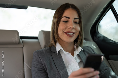Beautiful young business woman is traveling to work in the car © Milana