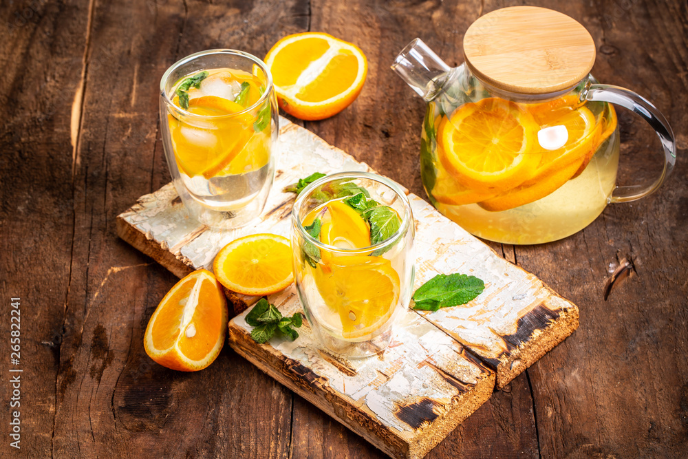 Orange detox water in mason jars on a wooden table. Healthy food, drinks, fitness, healthy nutrition diet concept Orange detox water in mason jars on a wooden table. Healthy food, drinks, fitness, healthy nutrition diet concept