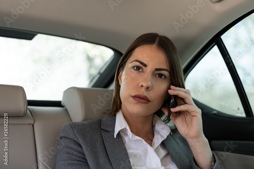 Beautiful young business woman is traveling to work in the car