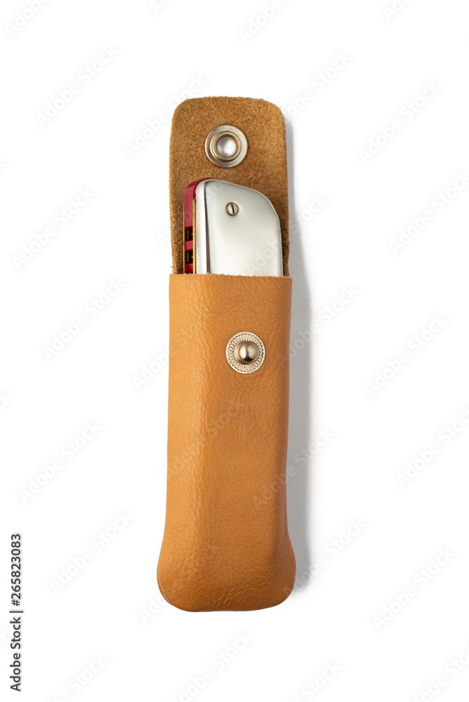 Harmonica in leather sheath on white background Harmonica in leather sheath on white background