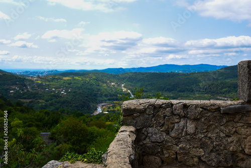 Ancient stone wall. View of valley from medieval Motsameta monastic complex near Kutaisi, Georgia. UNESCO world heritage site. View of the beautiful Georgian mountain valley and blue sky.