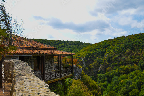 Ancient georgian Motsameta monastery in yellow green mountains near Kutaisi, Georgia in autumn. A small temple located in a picturesque location on a cliff at the winding river. Colorful image.