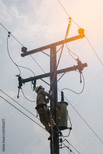 The power lineman use clamp stick (insulated tool) to closing a transformer on energized high-voltage electric power lines. The power lineman must be trained because it is a risky job.