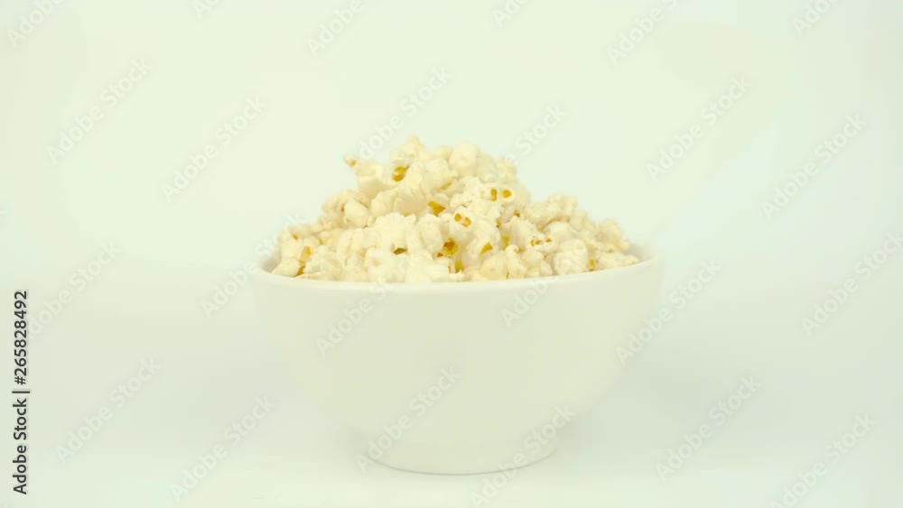 Eating Popcorn on White Bowl on White background. Unhealthy Food Eating Popcorn on White Bowl on White background. Unhealthy Food