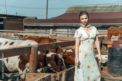 a beautiful woman on a farm feeds the cattle with hay © Екатерина Переславце