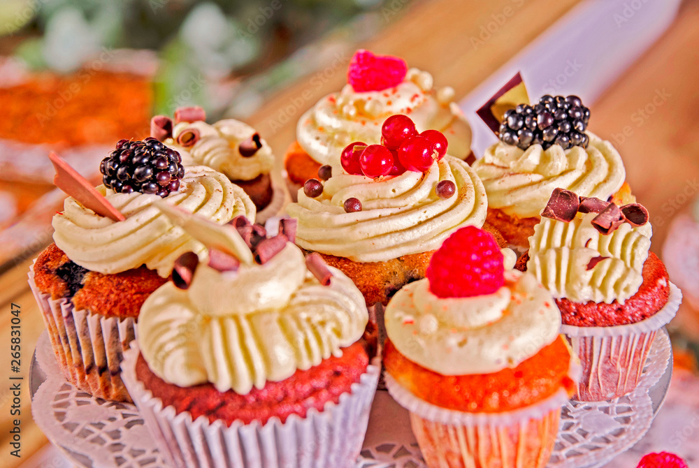 deliciously arranged muffins with cream filling and garnished with fruits on a wedding buffet