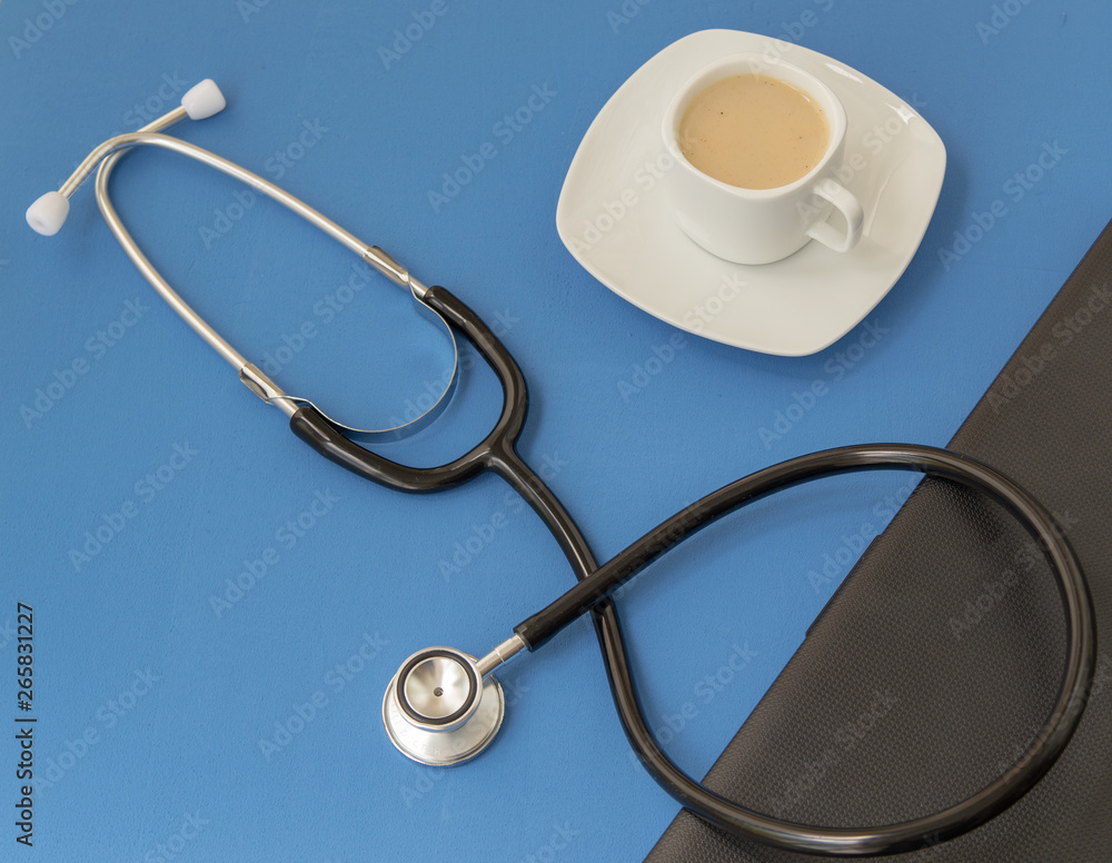 Stethoscope, cup of coffee and keyboard on a blue background. Medicine concept