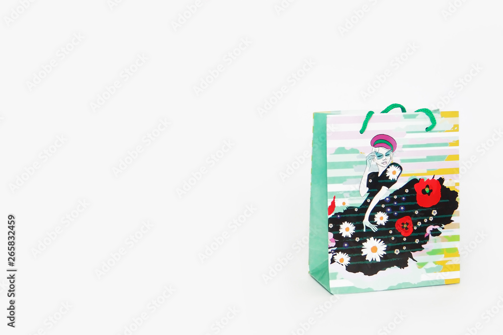 Obraz premium a multi-colored gift bag with a pattern in the form of a girl in a dress on a white background