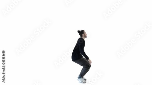 A man dancer runs up jumps up and bends his legs, slow motion freezes and falls to the floor. Black clothes on a white background. (ID: 265838649)