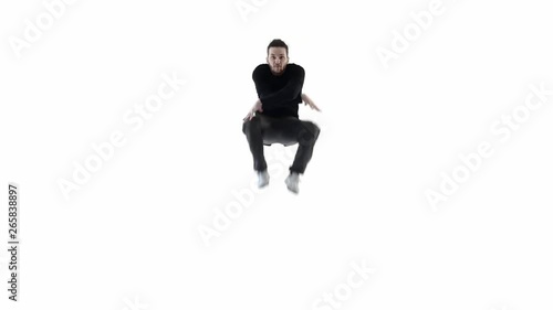 Man dancer jumping up spreading his legs.Black clothes on a white background.Slow motion (ID: 265838897)