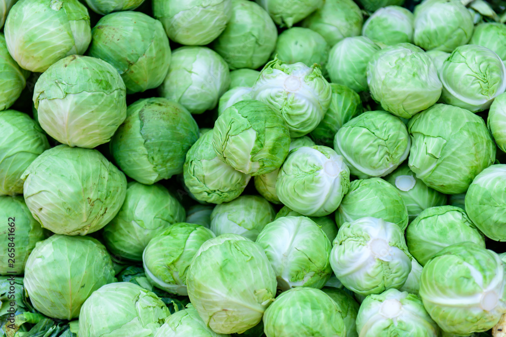 A natural pattern - fresh leafy green cabbages on the farmers' market. White cabbage as a background. A natural pattern - fresh leafy green cabbages on the farmers' market. White cabbage as a background.