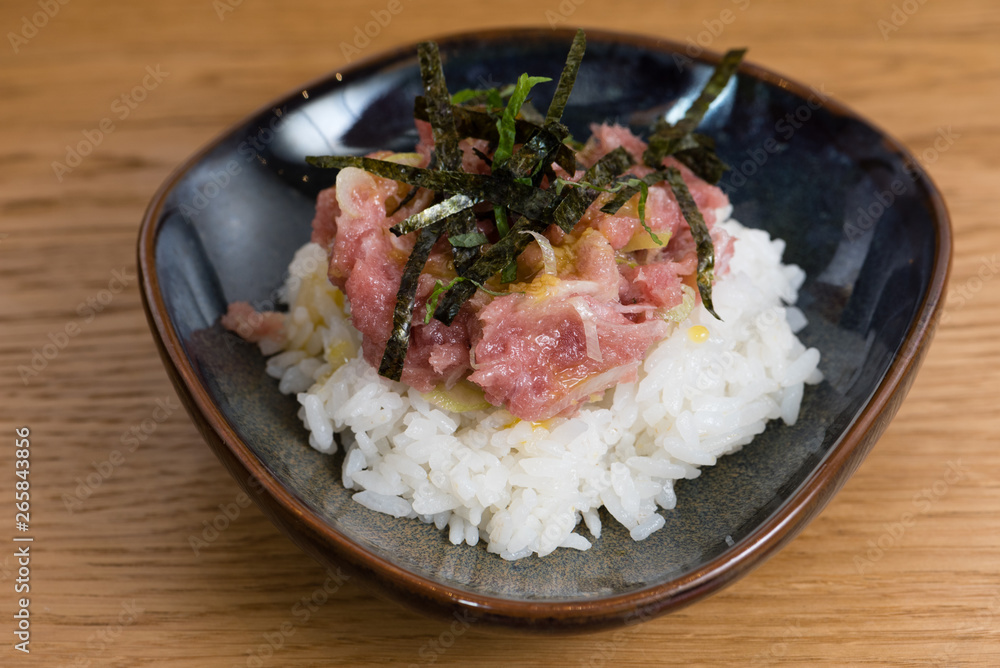 bowl with Kobe Beef tartare served with fried nori seaweed, egg yolk, chopped onion, over a bed of steamed white rice bowl with Kobe Beef tartare served with fried nori seaweed, egg yolk, chopped onion, over a bed of steamed white rice