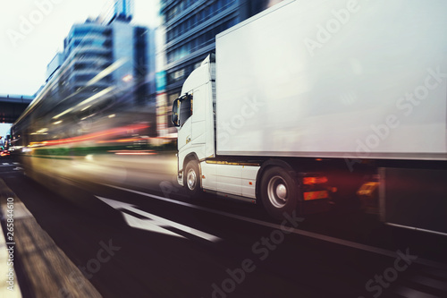 White truck moving fast on the road in a modern city with light effect