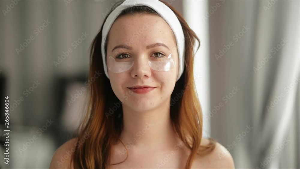 Portrait of Young Smiling Girl With Patches On The Face Under Eyes. Makeup and Beauty Treatments Concept. Skin Care, Spa, Cosmetology. Portrait of Young Smiling Girl With Patches On The Face Under Eyes. Makeup and Beauty Treatments Concept. Skin Care, Spa, Cosmetology.