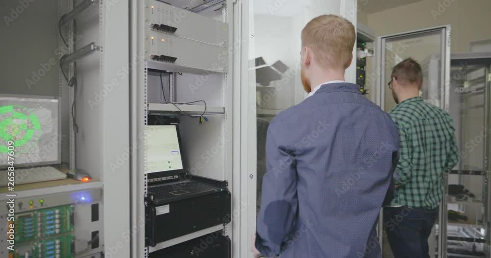 two technicians finish work in server room two technicians finish work in server room