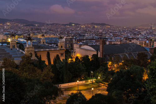 Aerial view of the Montjuic Park and the illuminated Barcelona city at twilight, Spain