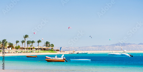Foto hotel with palm trees on the Red Sea in Egypt Dahab with boats and kite surfers