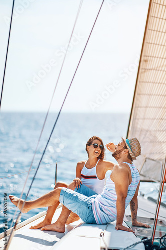 Smiling couple spending time together and relaxing on yacht.