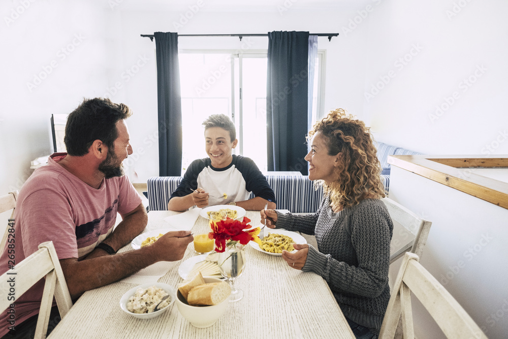 happy and cheerful caucasian family having lunch together at home. white wall and bright image. together enjoy the day smiling and looking with love and friendship