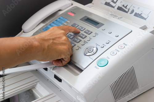 Hand man are using a fax machine in the office Business concept 