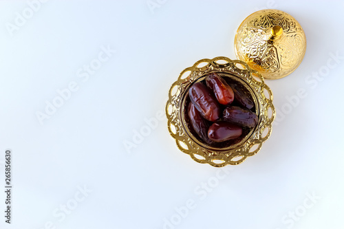 Organic dried dates in traditional arabic golden plate. Holy month Ramadan concept. Top view.