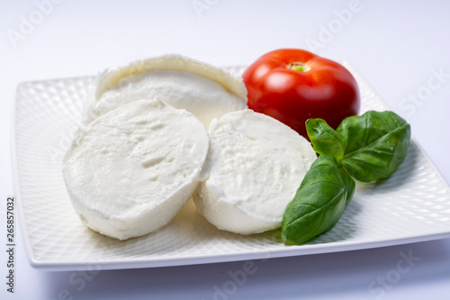 Soft white Italian cheese Mozzarella buffalo served with fresh tomato and green basil leaves