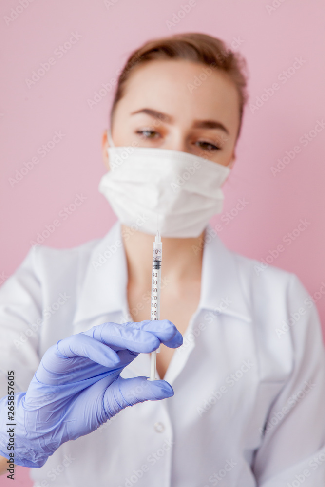 Close up nurse holding a syringe for injection, on pink background Close up nurse holding a syringe for injection, on pink background