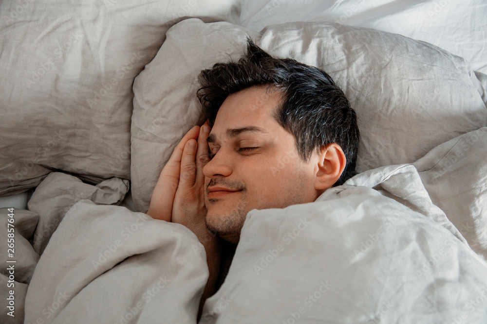 Yound man sleep in a bed at home. Yound man sleep in a bed at home.